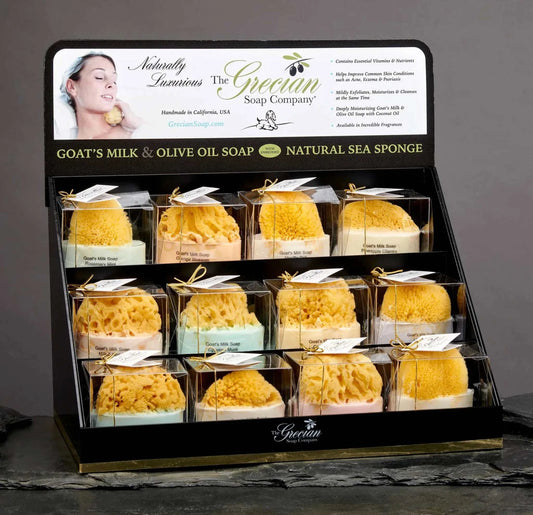 Goats milk sponge soap display with natural sea sponge in assorted colors.