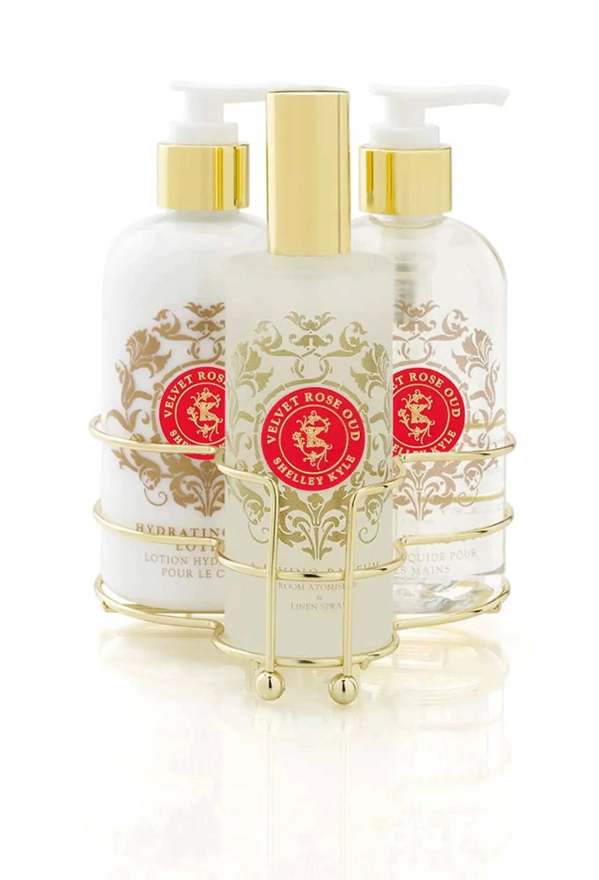 Velvet Rose Oud Three Piece Caddy with Room Spray, Body Lotion, and Liquid Hand Soap in a gold holder.