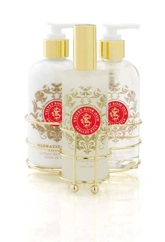 Velvet Rose Oud Three Piece Caddy with Room Spray, Body Lotion, and Liquid Hand Soap in a gold holder.